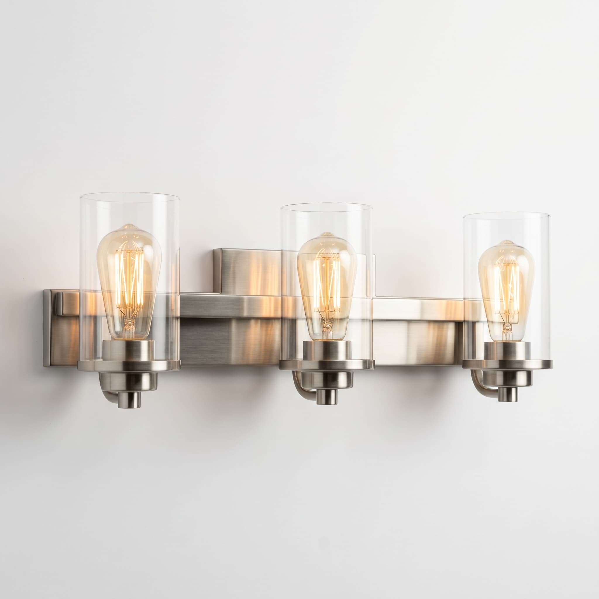 Three-light bath vanity bar with brushed nickel frame and clear cylindrical glass shades