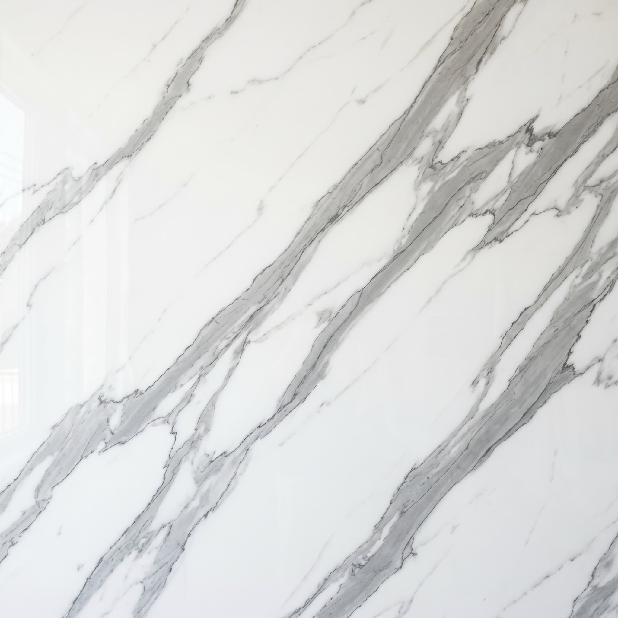 Calacatta polished marble-look porcelain tile — white field with bold dramatic gray veining