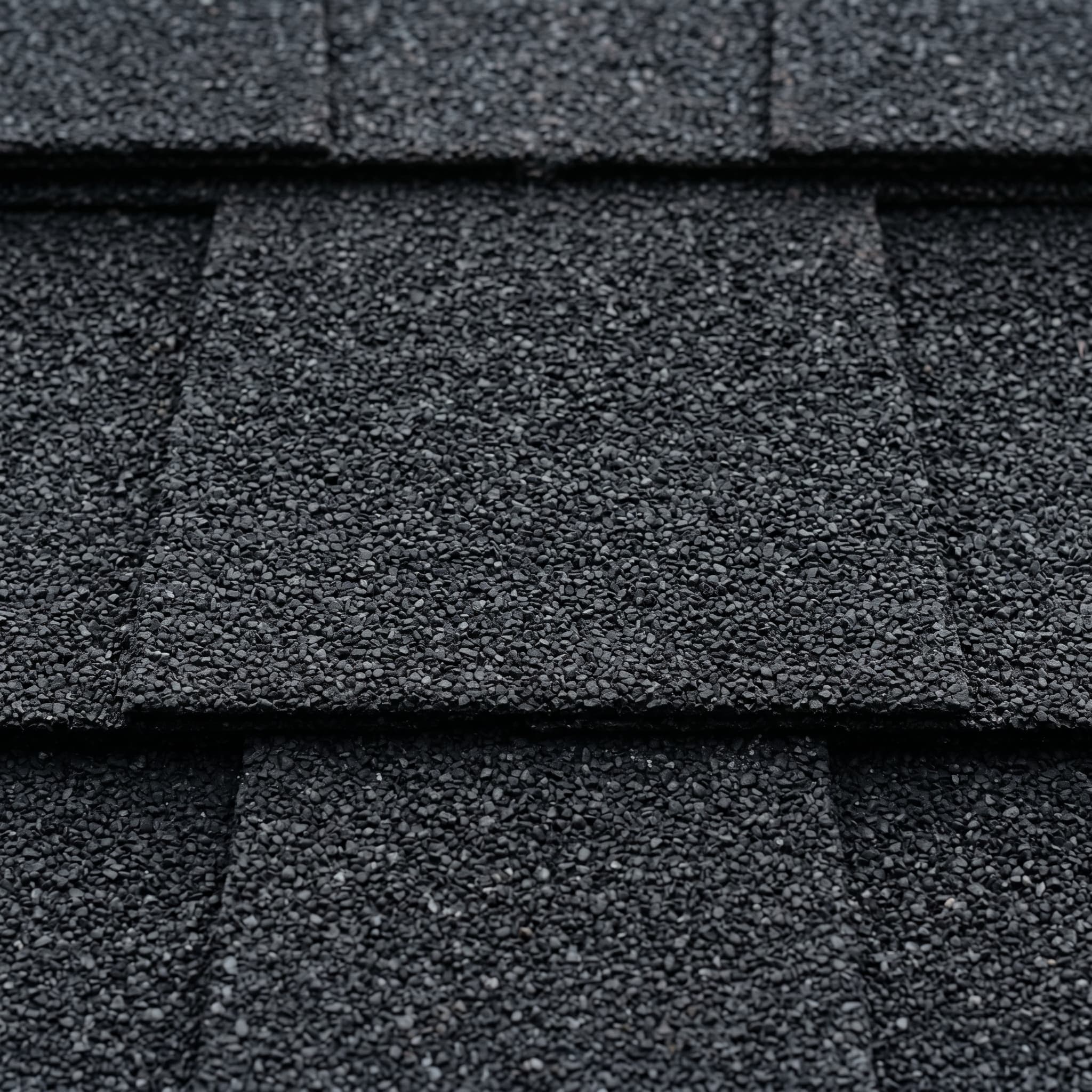 Deep matte black architectural asphalt shingles with subtle granule variation