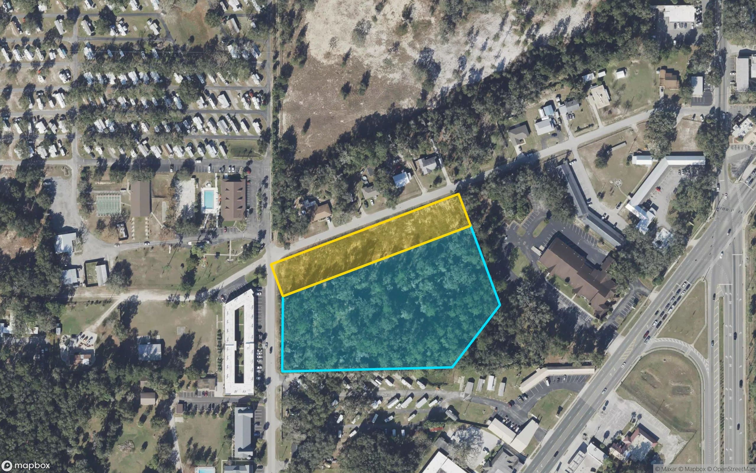 Mapbox satellite aerial with parcel boundaries overlaid — gold strip (Phase I, 1.30 ac, AR#29072 approved) directly north of the aqua trapezoid (Phase II, 4.18 ac, pre-development) on NE 52nd Court in Silver Springs Shores, Marion County, FL